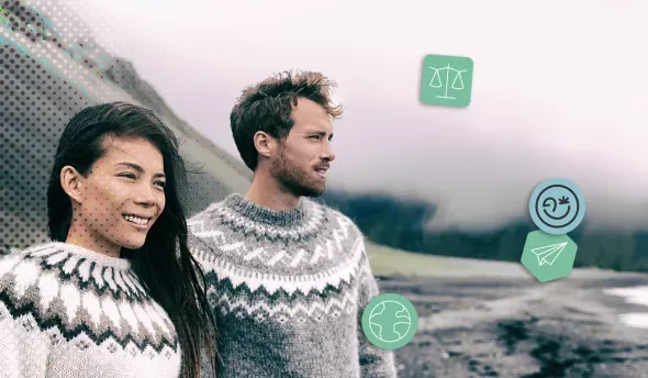 Un couple en pulls traditionnels observe la côte volcanique islandaise sous un ciel brumeux