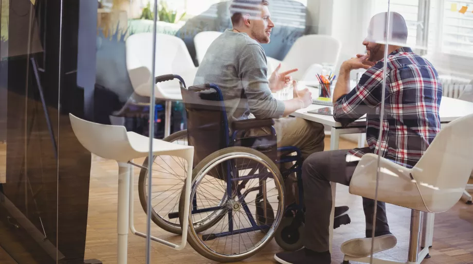 réunion entre un collaborateur en situation de handicap (fauteuil roulant) et son collègue