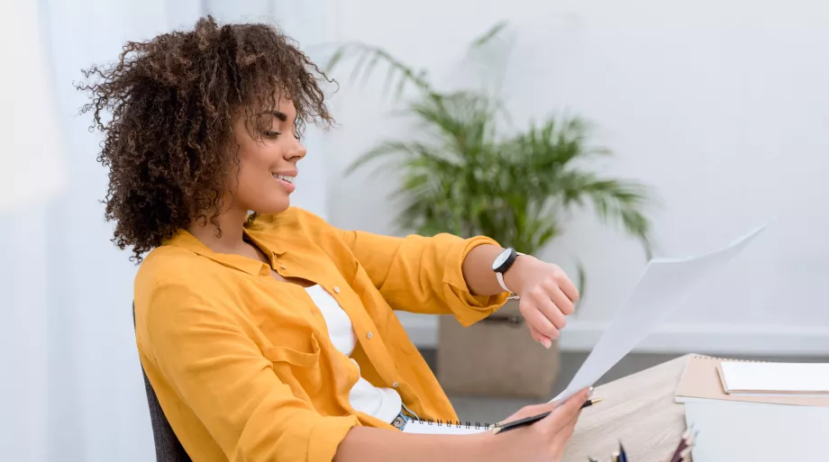 Femme au bureau qui regarde sa montre