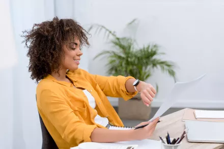 Femme au bureau qui regarde sa montre