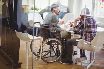 réunion entre un collaborateur en situation de handicap (fauteuil roulant) et son collègue