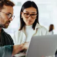 un homme et une femme utilisant un ordinateur 