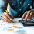 Une personne analysant un graphique avec une calculette à côté