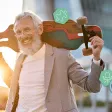 Homme senior souriant portant un skateboard sur l’épaule en tenue professionnelle décontractée
