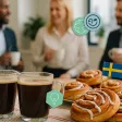 Deux tasses de café et des cinnamon buns suédois avec un drapeau suédois sur une table.