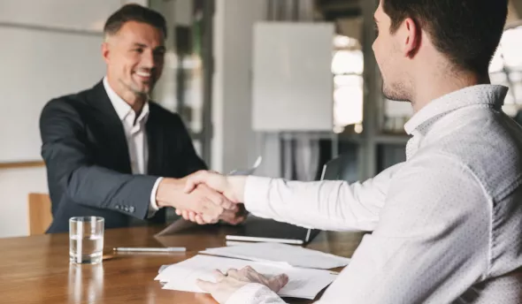 Un candidat qui sert la main à un recruteur