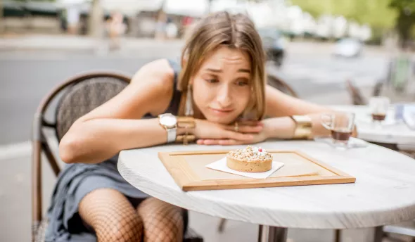 jeune femme avec un air dubitatif devant un gâteau