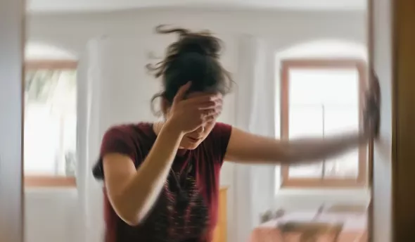 jeune femme qui se tient à un mur car elle ne se sent pas bien