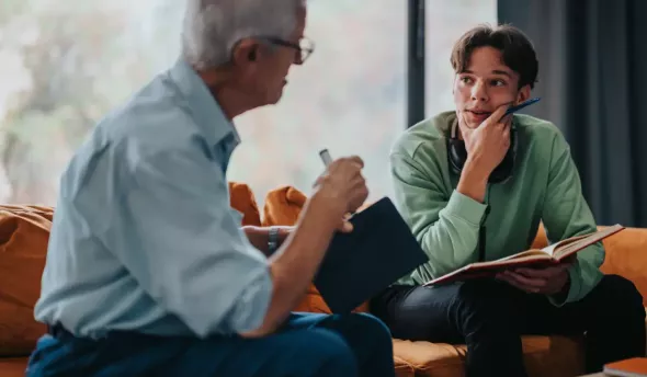 Un sénior et un jeune salarié en train de discuter dans un cadre cozy