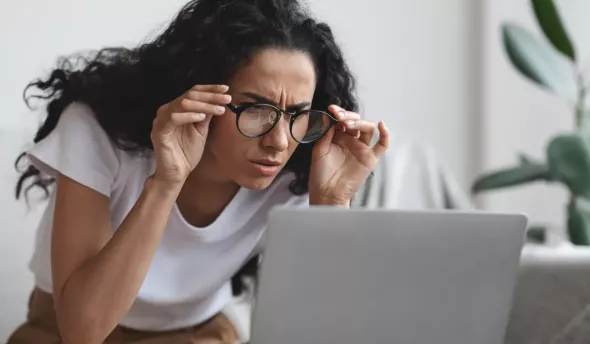 jeune femme regardant son PC avec un air perplexe