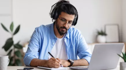 un homme avec un casque audio qui écrit