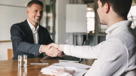 Un candidat qui sert la main à un recruteur