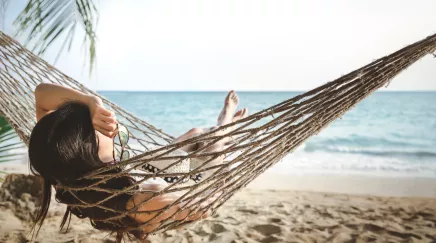 Femme dans un hamac en vacances à la plage