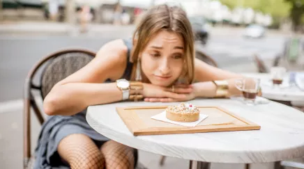 jeune femme avec un air dubitatif devant un gâteau