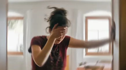 jeune femme qui se tient à un mur car elle ne se sent pas bien