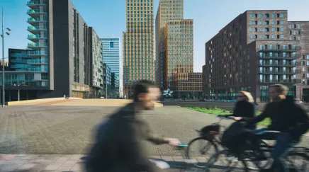 paysage avec building en arrière plan et personnes en vélo au 1er plan