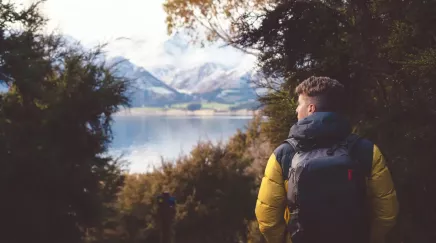 personne avec un sac à dos qui se promène dans un paysage avec montagnes