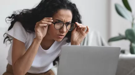 jeune femme regardant son PC avec un air perplexe