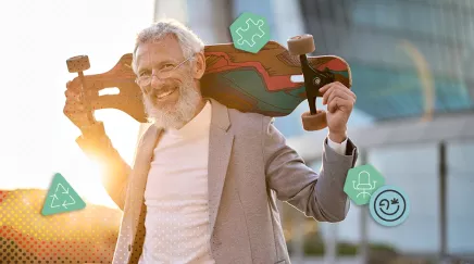 Homme senior souriant portant un skateboard sur l’épaule en tenue professionnelle décontractée