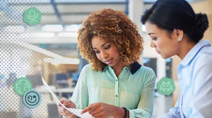 Deux collaboratrices discutent ensemble au bureau. 