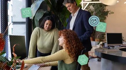 Trois collègues de générations différentes collaborent autour d’un ordinateur au bureau