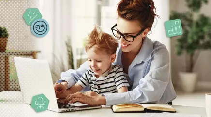 Mère souriante en télétravail avec son enfant sur les genoux, devant un ordinateur portable