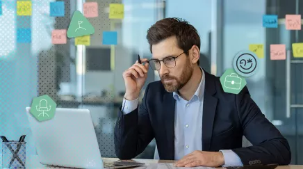 Homme concentré en costume travaillant sur ordinateur dans un bureau moderne
