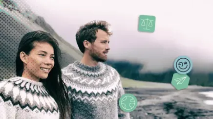 Un couple en pulls traditionnels observe la côte volcanique islandaise sous un ciel brumeux