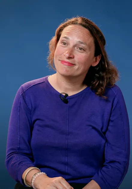 l'intervenante est assise sur un fauteuil et sourit