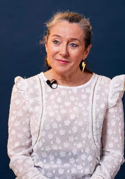 l'intervenante est assise sur un fauteuil et sourit